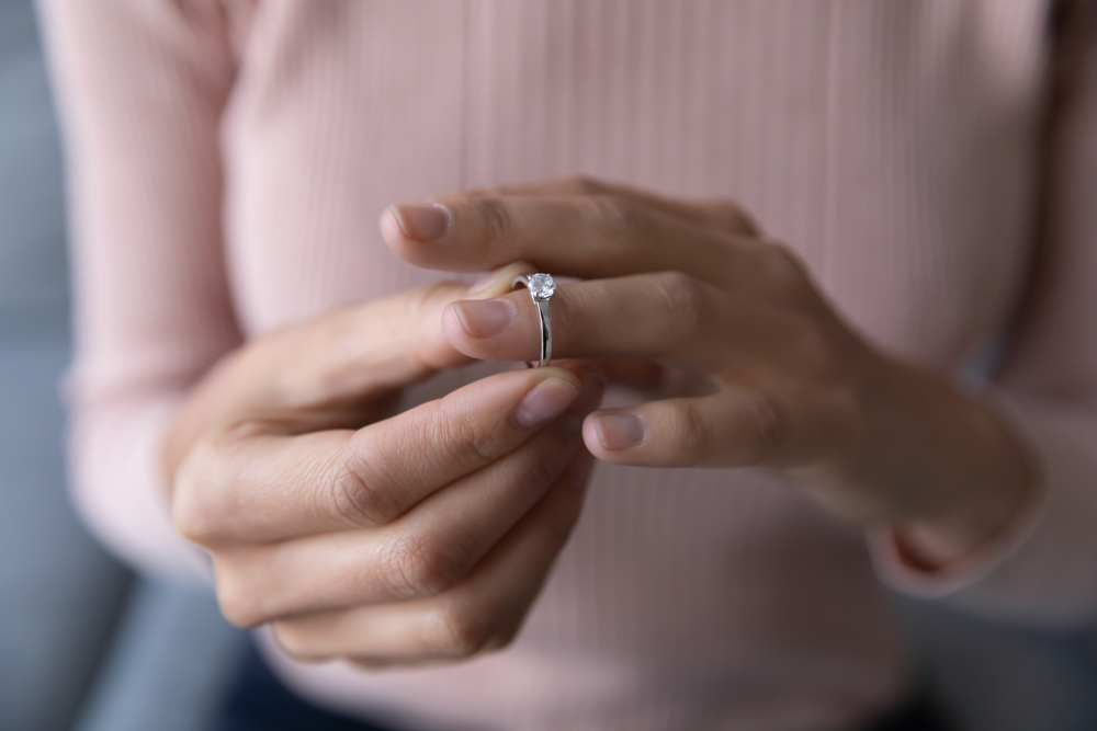 young woman taking off wedding ring