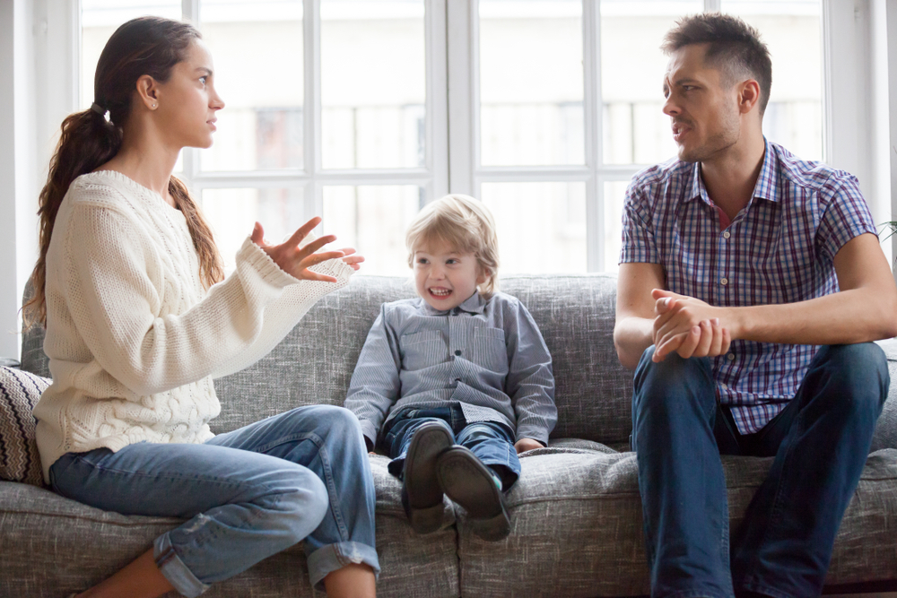 frustrated little boy son scared with mom and dad fighting at home
