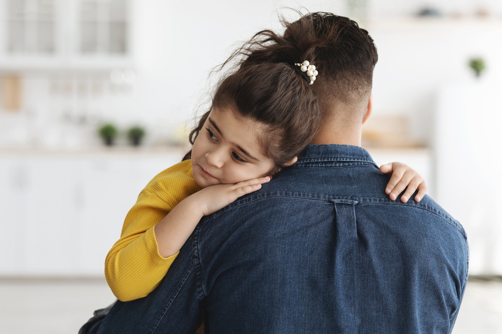Shot Of Caring Dad Comforting Upset Little Arab Daughter At Home