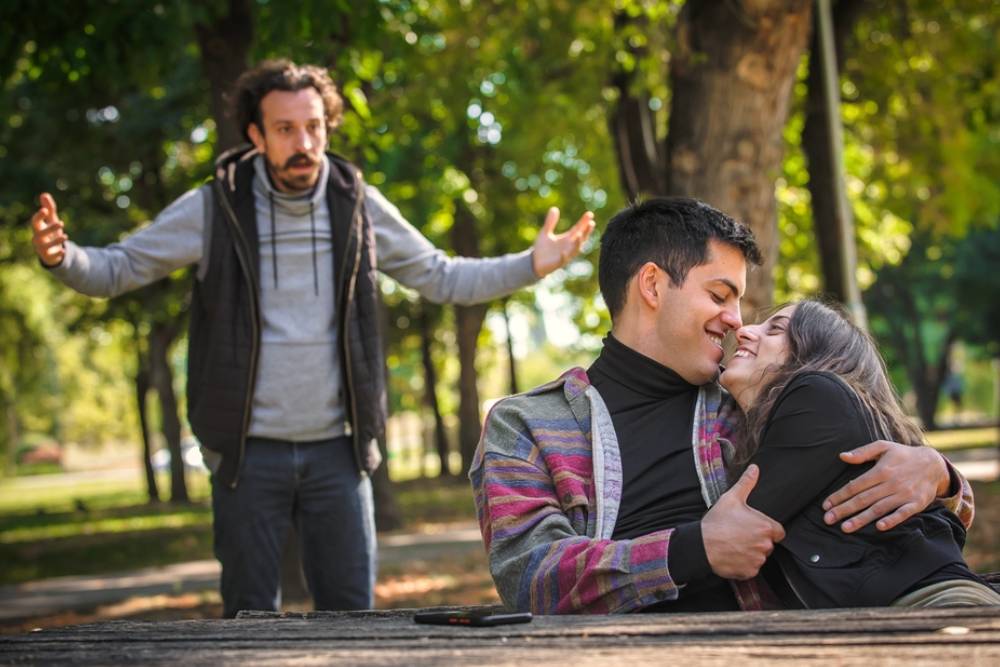 Adultery and infidelity concept. Shocked and surprised jealous boyfriend in problem with his girlfriend whose cheating him with his friend