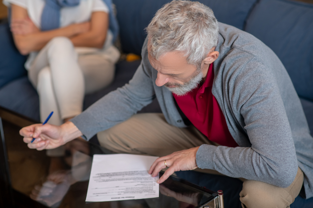 Petition for divorce. An elderly man filling a petition for divorce