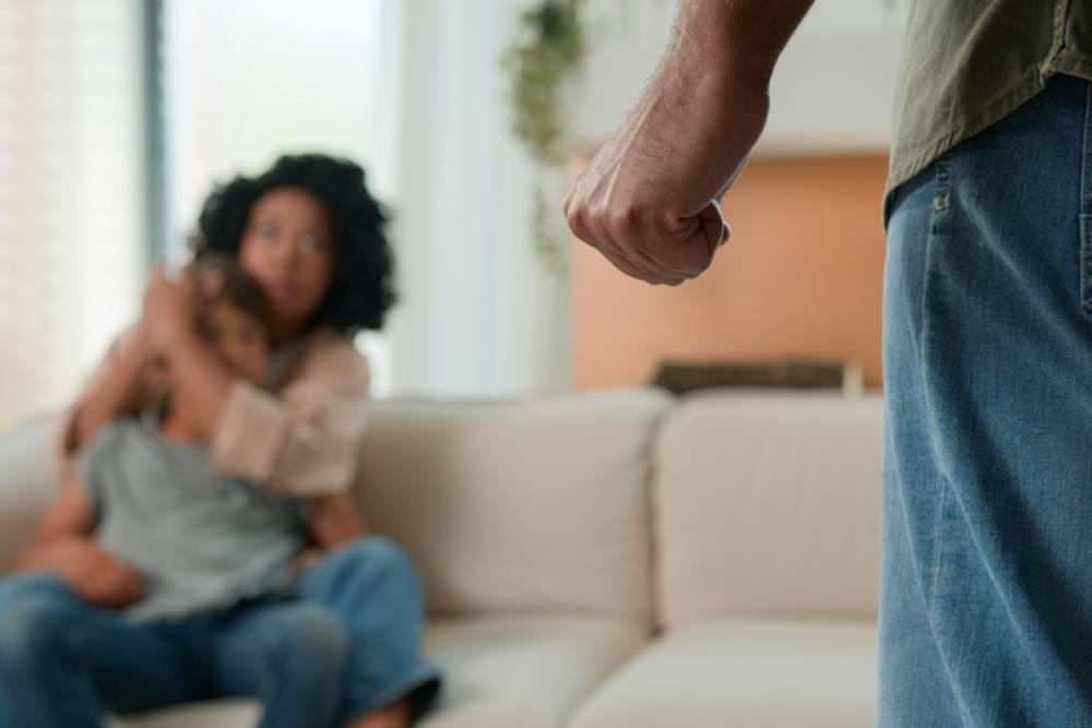 Domestic violence physical abuse in multiracial family scared woman in fear protecting little boy child son
